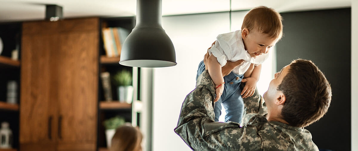 veteran-lifting-his-child-in-their-newly-renovated-home